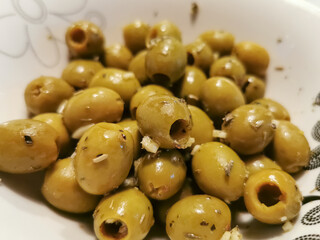 Detailed view at healthy starters, green olives, garlic, coriander and olive oil