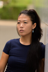 Portrait of beautiful rebel Asian woman thinking outdoors