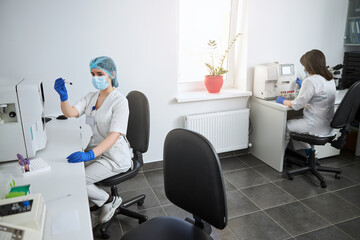 Focused biochemist examining the contents of a lavender-top vacutainer