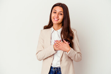 Young Indian business woman isolated on white background has friendly expression, pressing palm to chest. Love concept.