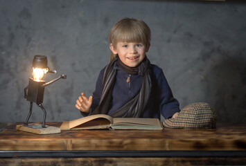 Fototapeta na wymiar a preschool boy reads a book with fairy tales, he is interested