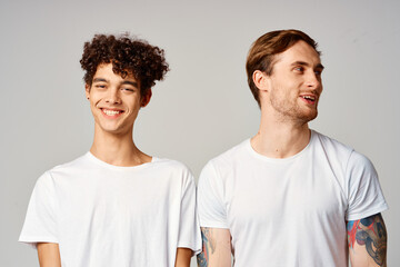 Two cheerful friends in t-shirts stand side by side isolated background joy