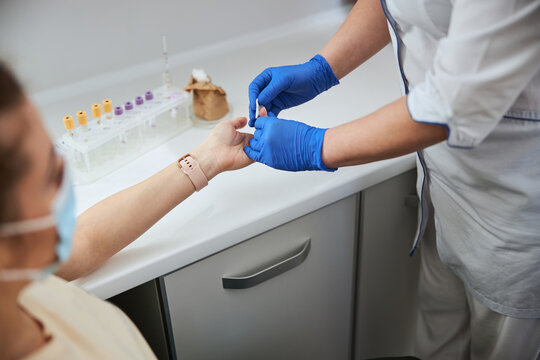 Nurse preparing a female for a finger prick blood test