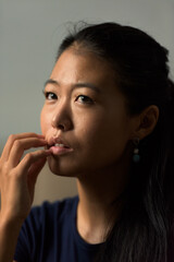 Obraz premium Close-up portrait of beautiful rebel Asian woman face thinking outdoors