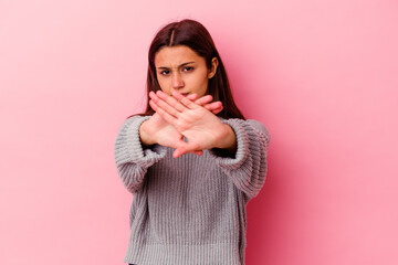 Young Indian woman isolated on pink background standing with outstretched hand showing stop sign, preventing you.