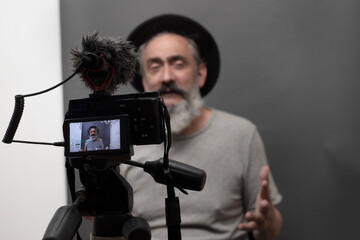 older male blogger talking to camera