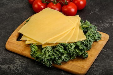 Sliced Gauda cheese over board