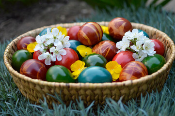 Fototapeta na wymiar basket of colorful Easter eggs lying in the grass