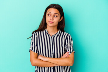 Young Indian woman isolated on blue background dreaming of achieving goals and purposes