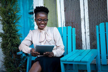 Fototapeta premium Businesswoman using tablet in cafe. Beautiful woman sitting in cafe, reading the news online.
