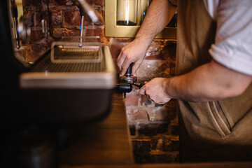 Person tamping coffee grounds in a filter basket.