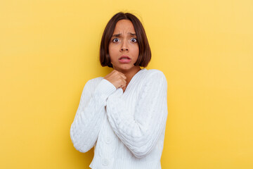 Young mixed race woman isolated on yellow background scared and afraid.