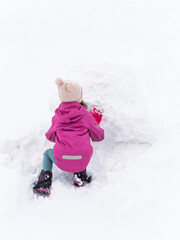 Fototapeta na wymiar Kid rolling snowball.