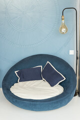 Close up of decor with blue armchair and long Edison lamps