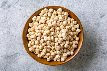 dry chickpeas in wooden bowl on concrete background Healthy eating, vegetable protein concept Top view Flat lay