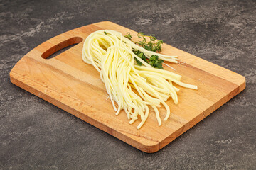 Chechil spaghetti cheese over board