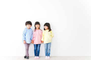 Fototapeta premium 壁に並ぶ3人の幼稚園児