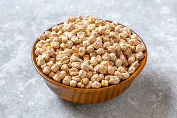 dry chickpeas in wooden bowl on concrete background Healthy eating, vegetable protein concept Top...