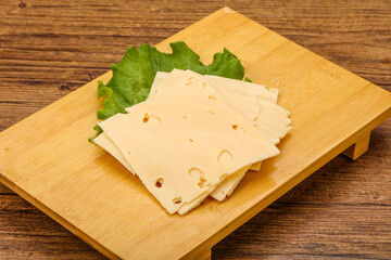 Sliced yellow cheese over board