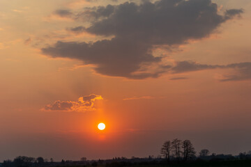 Round sun and hazy pink sky with clouds