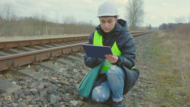 Worker taking photos of rails on tablet