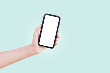 Close-up of male hand holding smartphone with white mockup on blue background.