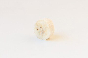 A slice of unpeeled banana isolated on white background. Skewed view.