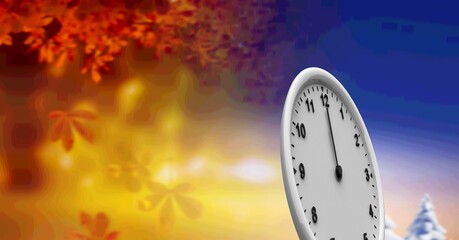 A clock face standing against a background of autumn leaves and winter landscape