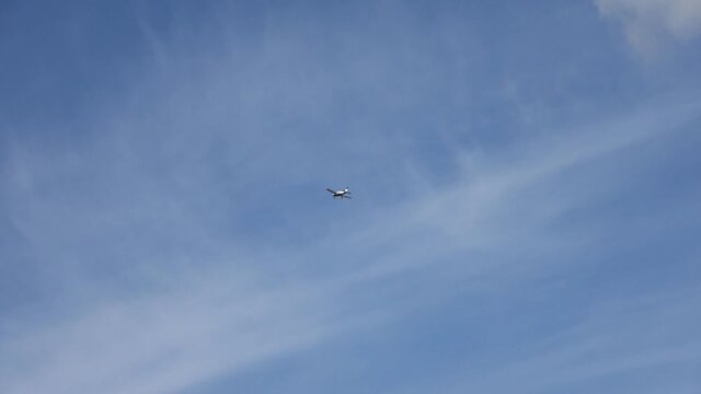 Light aircraft with one propeller flying in the blue summer sky.