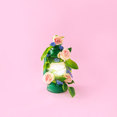 A shining lantern with spring flowers. On a pastel pink background. Minimal composition.