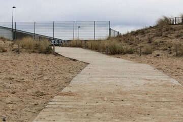 Beach with a wooden path as a closeup on a cold day