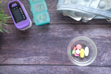 Close up of many colorful pills and capsules in a small container on table 