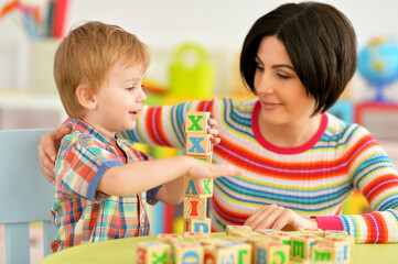 Fototapeta premium Woman and little boy playing with cubes