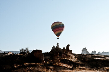 TURKEY, CAPPADOCIA, GOREME:  Aerial scenic view of hot air balloons flying over mountains landscape with fairy chimneys