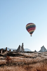 Fototapeta na wymiar TURKEY, CAPPADOCIA, GOREME: Aerial scenic view of hot air balloons flying over mountains landscape with fairy chimneys