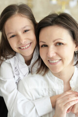 Beautiful young mother and  cute little daughter posing