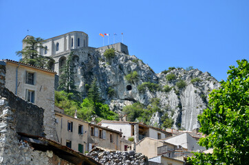 Fototapeta na wymiar View to the Citadel (fortress) of Sisteron on a rock in Provence-Alpes-Côte d'Azur, old medieval houses below, blue sky background 