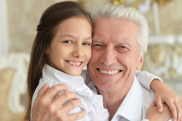 Happy elderly man with  cute granddaughter