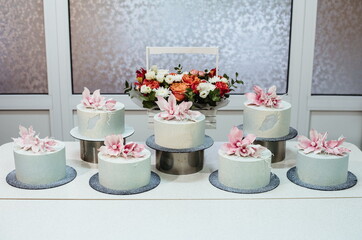 Showcase with cakes. The cakes are covered with chocolate velor and decorated with sugar flowers.
