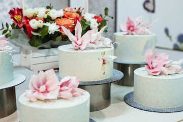 Showcase with cakes. The cakes are covered with chocolate velor and decorated with sugar flowers.