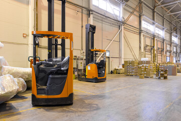 Forklift loader parking at logistics warehouse. Pallet stacker truck equipment inside of a modern warehouse storage