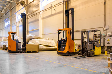 Forklift loader parking at logistics warehouse. Pallet stacker truck equipment inside of a modern warehouse storage