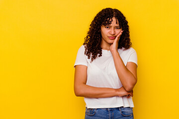 Young mixed race woman isolated on yellow background who feels sad and pensive, looking at copy space.