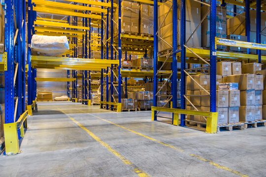 Interior of a modern warehouse storage with rows and goods boxes on high blue yellow shelves