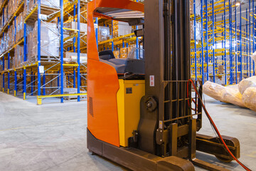 Electrical forklift loader charging in the warehouse. Pallet stacker truck equipment inside of a modern warehouse storage