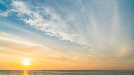 Sunset sky over sea in the evening with colorful orange sunlight on cloudy