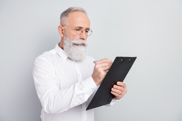 Photo of minded focused serious old man look write clipboard plan businessman isolated on grey...