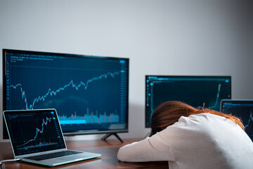 tired female beginner trader sleeping near monitor with stock chart at workplace