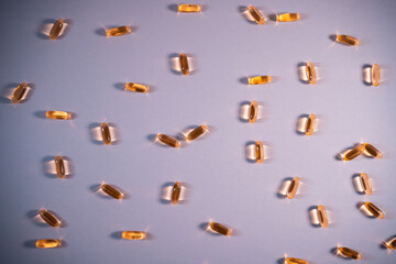 healthy golden fish oil capsules omega 3 vitamins on purple background