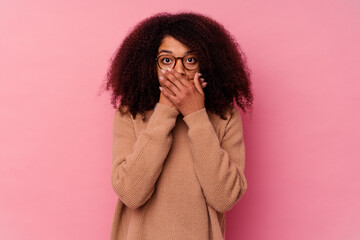 Young african american woman isolated on pink background shocked covering mouth with hands.